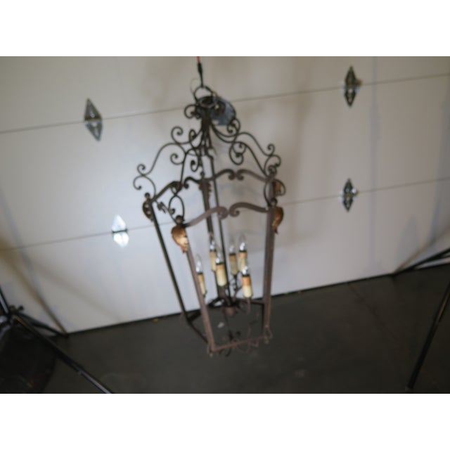 This French style inside/outside lantern showcases the timeless artistry of wrought iron craftsmanship. It's intricate...