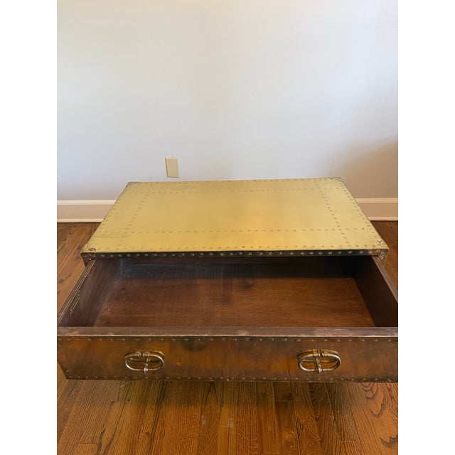 A striking vintage brass-clad campaign-style coffee table handcrafted in Spain by Sarreid Ltd., one of the premier...
