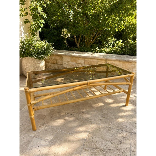 A beautiful Danish bamboo and glass coffee table, circa 1960s, with a warm bamboo frame and smoked glass top. The table...