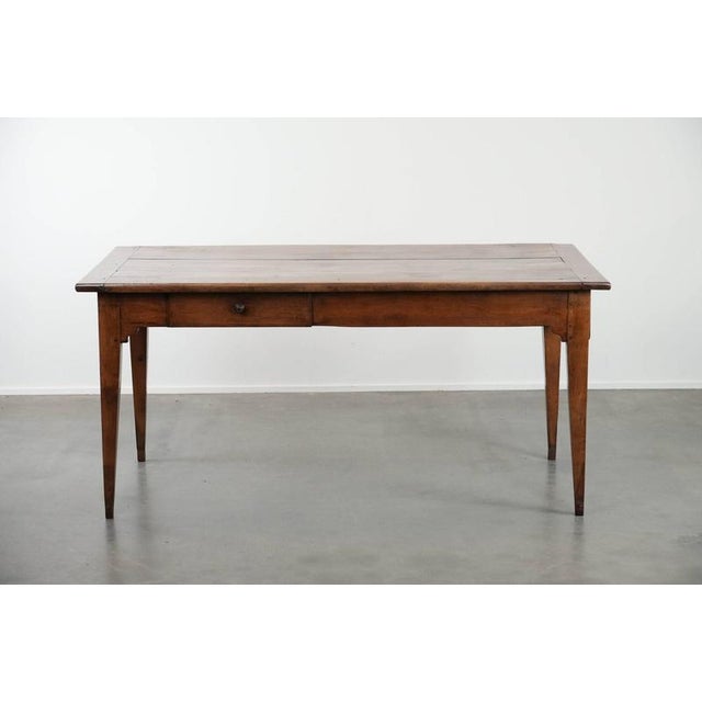 We are offering this elegant and subtle antique French dining table made from fruit tree wood. This elegant antique French...