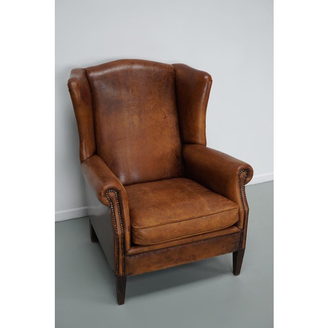 This cognac-colored leather club chair comes from the Netherlands. It is upholstered with cognac-colored leather and...