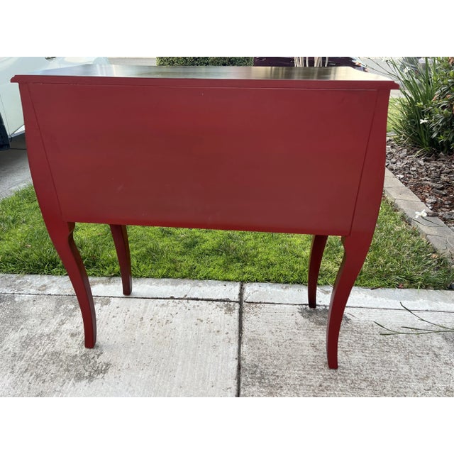 This nice piece features a sharp Red painted body with two doors and a Dark Brown Stained top. The ornate handles...