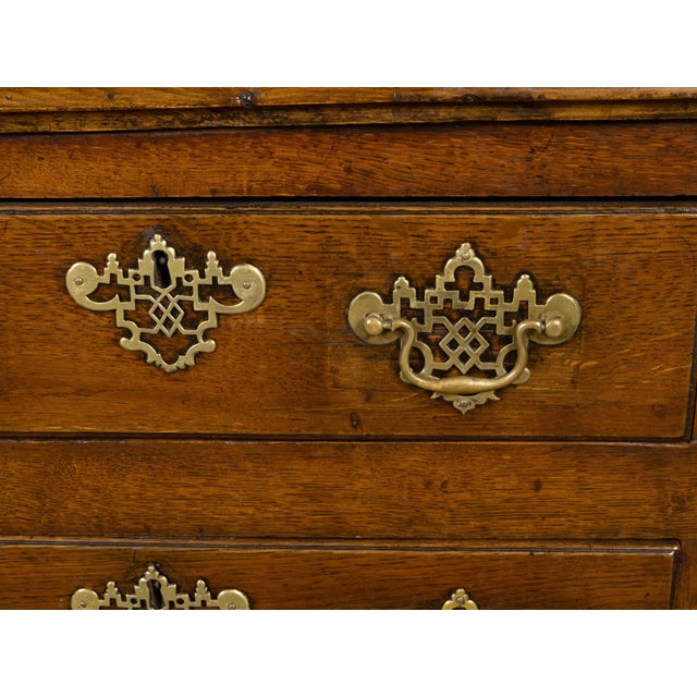 An English oak dresser base from the early 19th century with T-shaped drawers, semi Doric columns, two doors and brass...