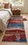 A hand-knotted runner in the Persian Gabbeh style, woven as a landscape in bands of madder red, camel brown, indigo and...