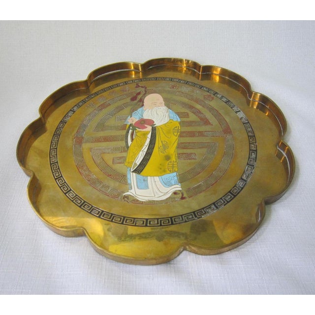 Charming scallop edged Chinese brass tray with the enameled figure of an Immortal. It measures 12"D x .5"H and is in...