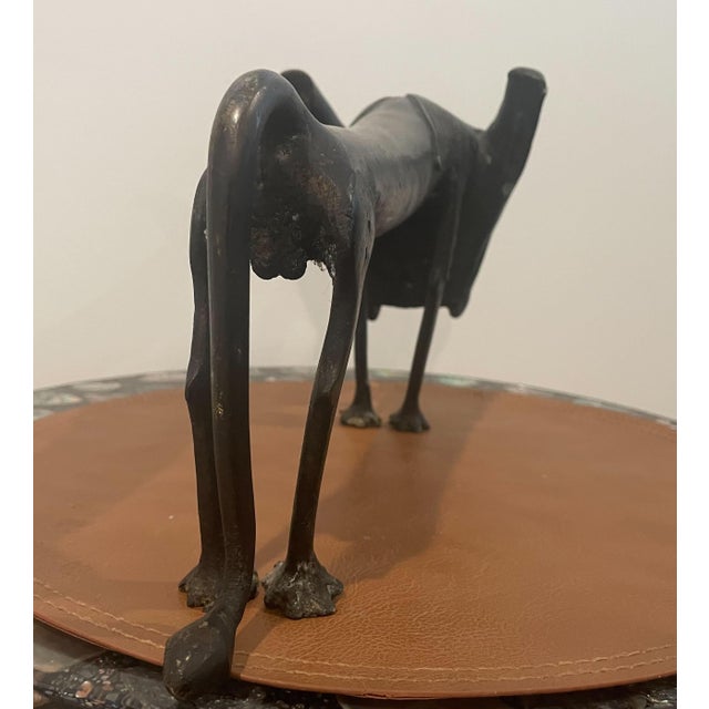 From Benin, Decorative African bronze sculpture depicting a stylized dog, created in the manner of traditional Fon...