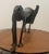 From Benin, Decorative African bronze sculpture depicting a stylized dog, created in the manner of traditional Fon...