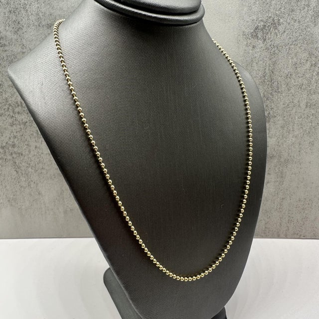This classic 14kt yellow gold ball bead chain features a timeless design with a polished finish, perfect for wearing alone...