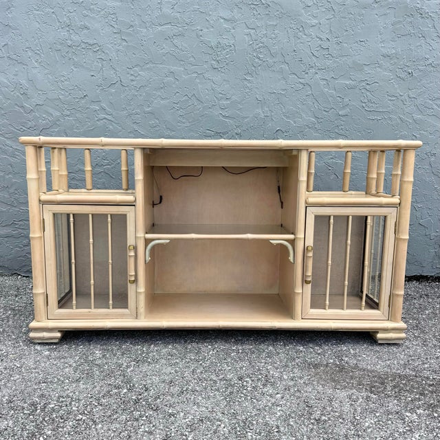 A striking vintage coastal credenza/étagère crafted in faux bamboo with a soft, sun-washed finish. The design features...