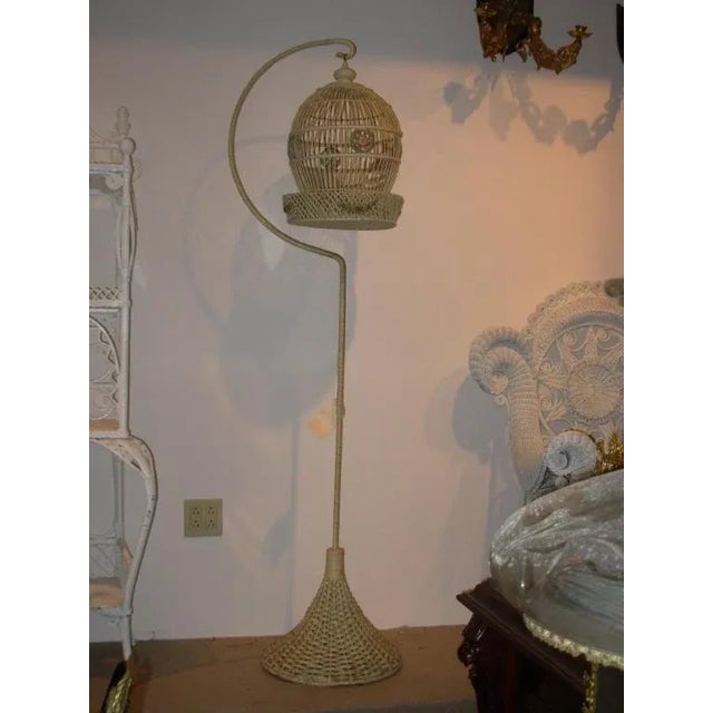 An unusual wicker bird cage in original paint, with barbola trims and original bird inside.