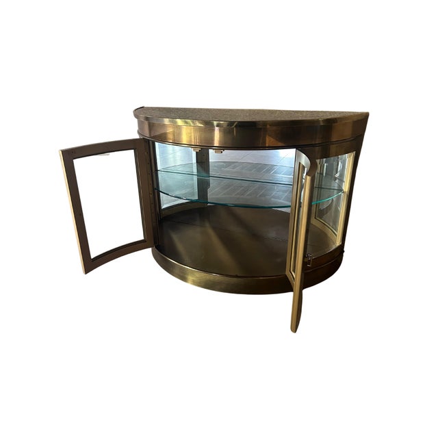 A striking example of Mastercraft’s glamorous 1970s design, this illuminated demilune cabinet combines sculptural form...