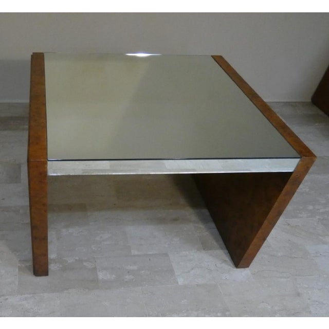 This coffee table, produced in the 1970s, features an elegant burl veneer and a mirrored top and edges, creating a refined...