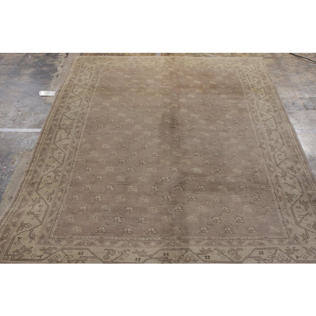 Originating from Turkey circa 1960-1970, this 7x10 vintage Oushak rug enjoys a luxurious, elegant color palette of gray...
