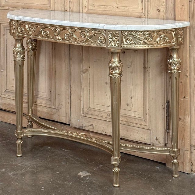 Antique French Louis XVI Giltwood Demilune Console with Carrara Marble is a masterpiece of elegance that will provide the...