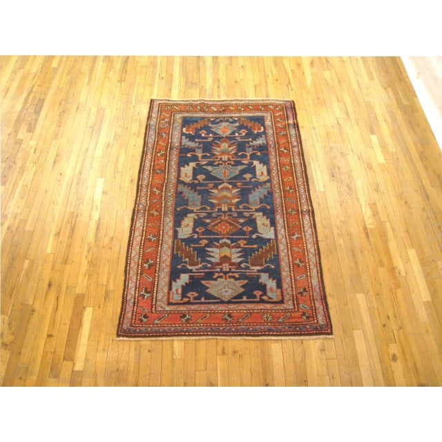 An antique Persian Hamadan oriental rug, size 6'2" x 4'0", circa 1920. This small, handwoven wool carpet features a large-...