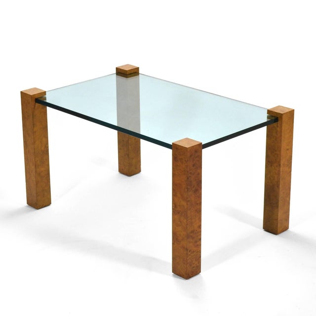 This striking design has a great minimalist aesthetic. Four legs of burled wood set in the corners like a parson's table...