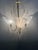 Three-light chandelier in brass and silver plating. Shell-shaped glass in satin white. Up to 250V (Europe/UK Standard).The...