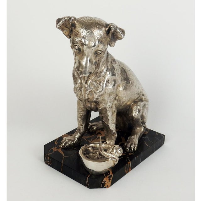 Silvered bronze sculpture depicting a Jack Russell dog sitting in front of a bowl on which a snail is walking, signed F...