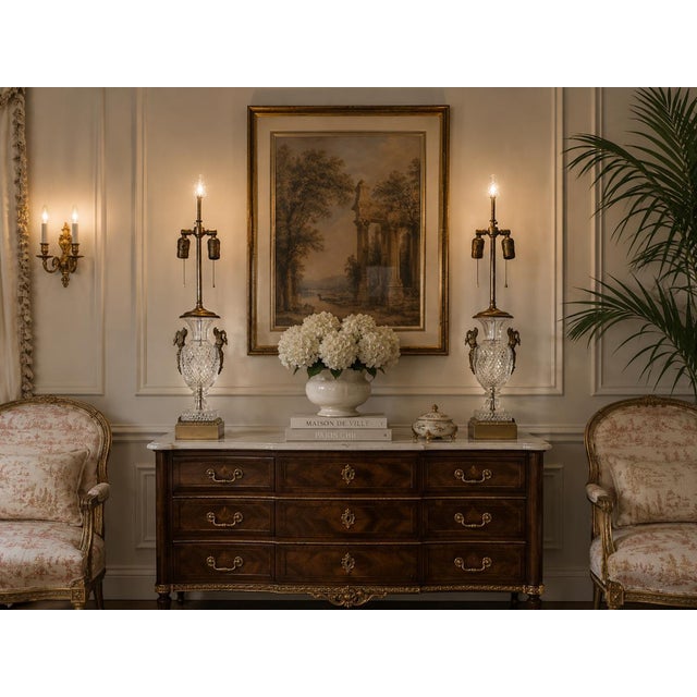 Elegant pair of vintage French Empire Neoclassical-style table lamps featuring substantial cut crystal bodies with...