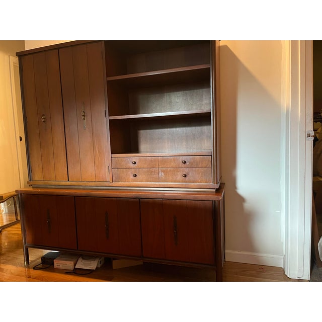 A beautifully crafted vintage Mid-Century Modern hutch, dating to the 1950s, featuring clean lines, warm wood tones, and...
