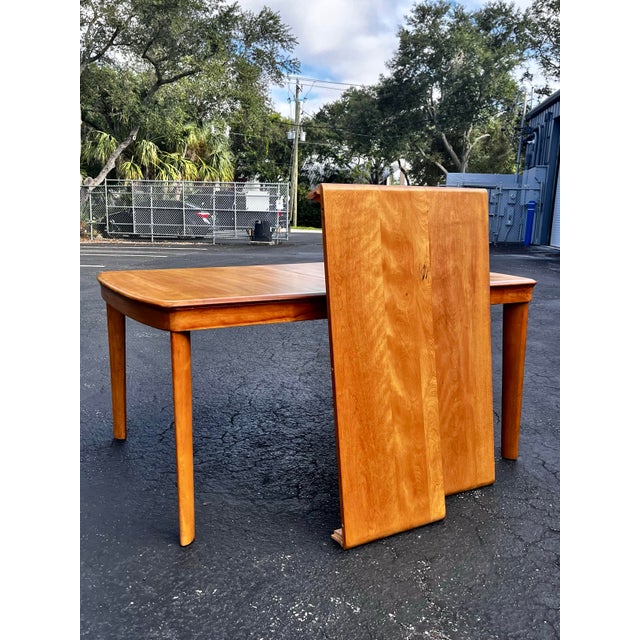 Mid-century modern natural extendable dining table. Includes two self-storing leafs. Constructed in the style of Heywood-...