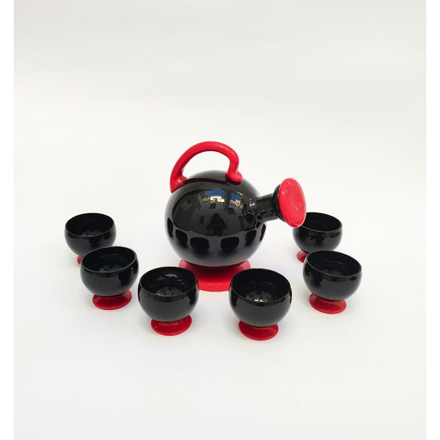 Rosolio set, designed by Napoleone Martinuzzi In black and red Murano glass Vintage 1970s Consisting of a black bottle...