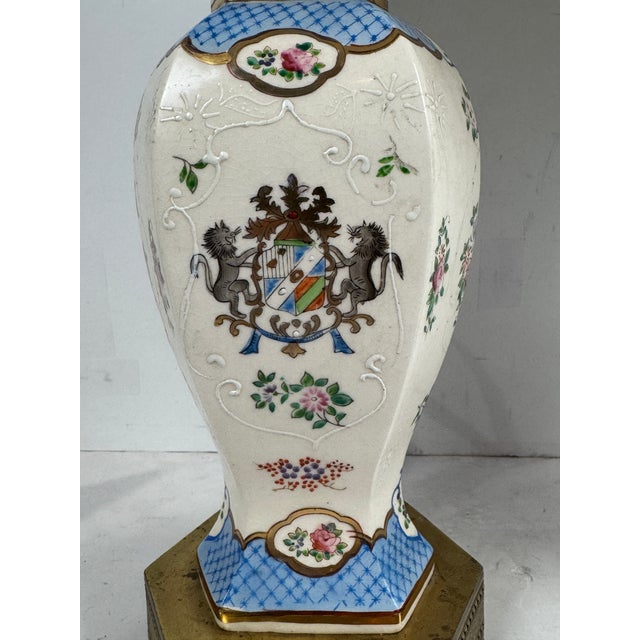 Beautiful pair of Hand Painted Porcelain Table Lamps with Lion Crest and detailed Brass Base. Other side shows a floral...