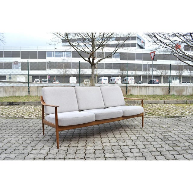 This Knoll Antimott sofa features its original upholstery bright fabric with innerspring seating and an walnut frame. We...