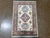 Hand-knotted Pakistani Kazak wool rug featuring an ivory field with a central geometric medallion and stylized tribal...