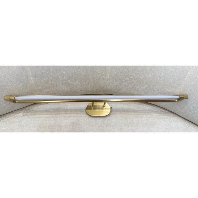An elegant aged brass picture light with a slim, modern look and soft integrated LED glow, designed to illuminate decor,...