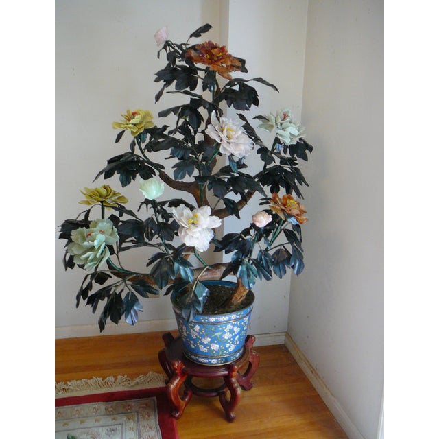 This life-size intricately designed with 12 flowers made of jade, carnelian, and quartz in a cloisonné enamel pot is the...