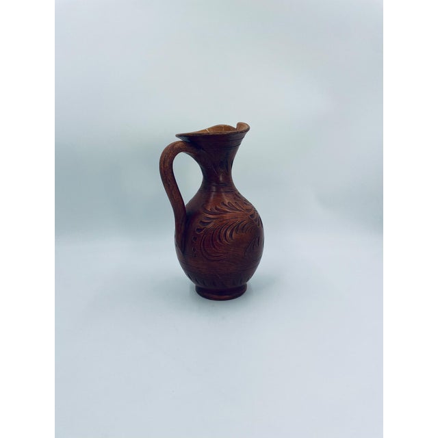 A decorative vase from Italy, crafted from high-quality ceramic. The vase features a hand-formed jug shape with a...