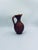 A decorative vase from Italy, crafted from high-quality ceramic. The vase features a hand-formed jug shape with a...