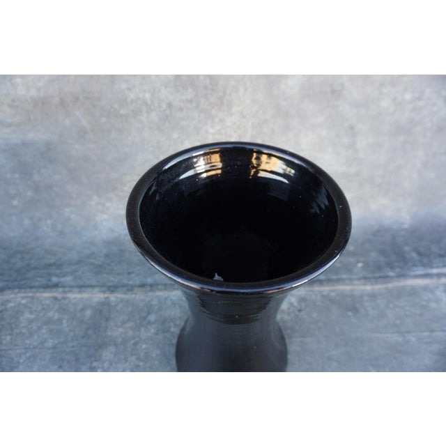 A refined Bauer Pottery vase, produced in Los Angeles circa 1930, featuring a tall, waisted silhouette with a gently...