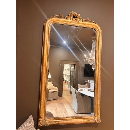 Large French giltwood Louis Philippe mirror featuring a classic rectangular form with softly rounded upper corners,...