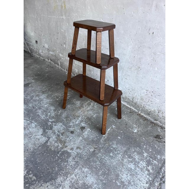 A charming set of three solid oak nesting tables dating from the mid-20th century. Featuring a warm dark oak finish,...