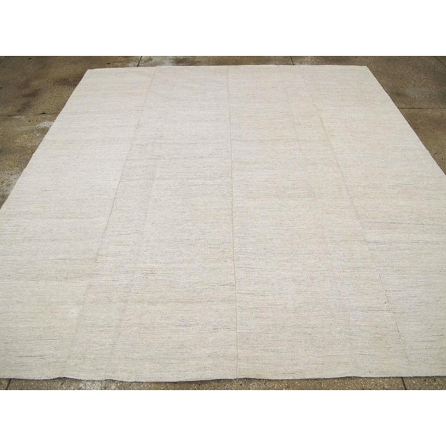 This Mid-20th century Turkish flatweave kilim rug, embodies the beauty of minimalist design through its soft, neutral...