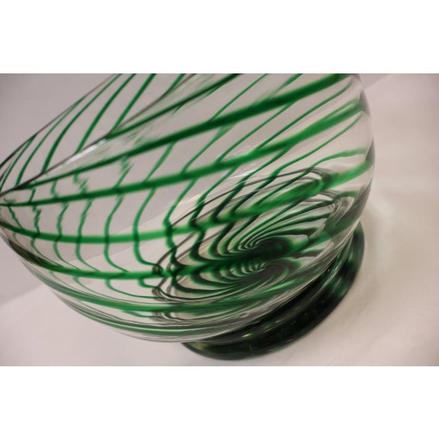 Add a bold splash of artistry to your space with this stunning green swirl glass bowl. Featuring a mesmerizing emerald-...
