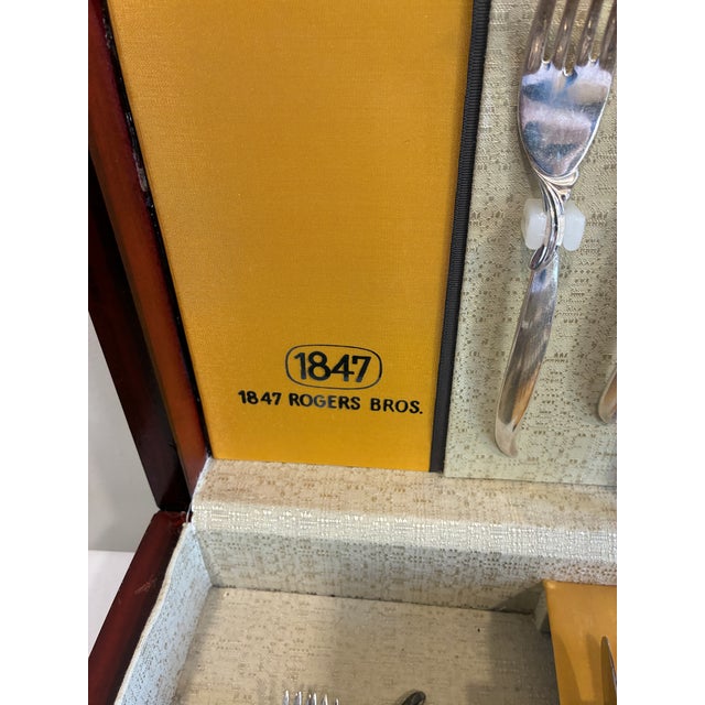 A handsome vintage 1847 Rogers Bros. silverplate flatware set in the iconic Flair pattern, presented in its original wood...