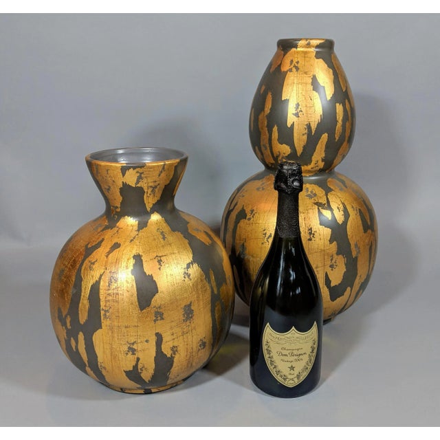 This gold leaf and charcoal gray painted vase is a stunning example of how a simple shape inspired by nature can be...