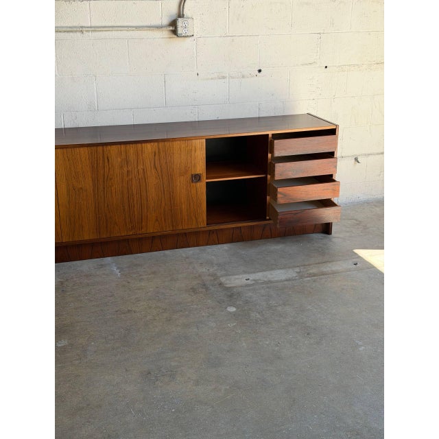 This exceptional long low sideboard offers a clean minimalist profile with sliding doors and internal shelving. Designed...