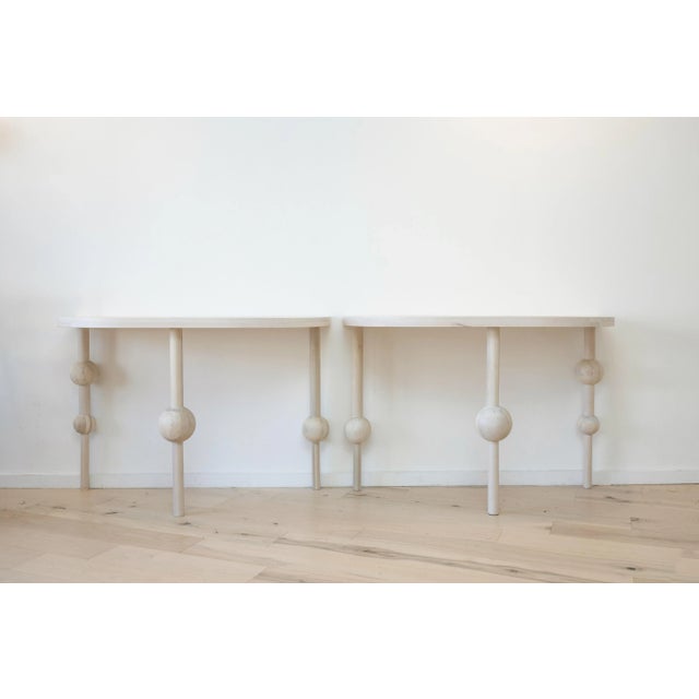 Sculptural ivory white demilune side table with asymetrical spheres on legs by Farnady Interiors