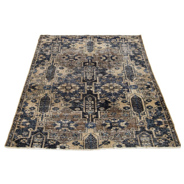 This vintage Persian wool rug boasts a captivating light brown primary color with stunning blue all-over accents. This rug...
