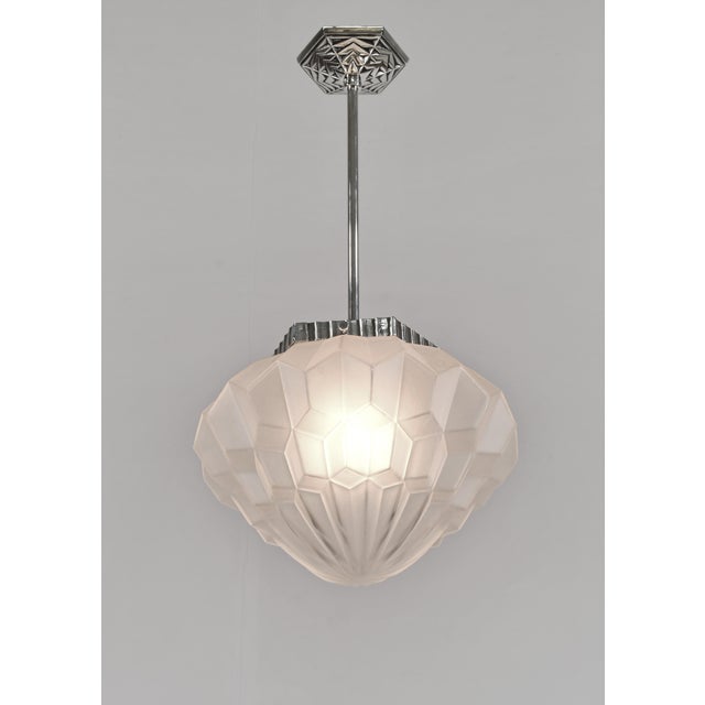 Degué A French 1925-1935 art deco pendant light in nickel plated bronze. The mounting holds a nice ball shaped shade in...