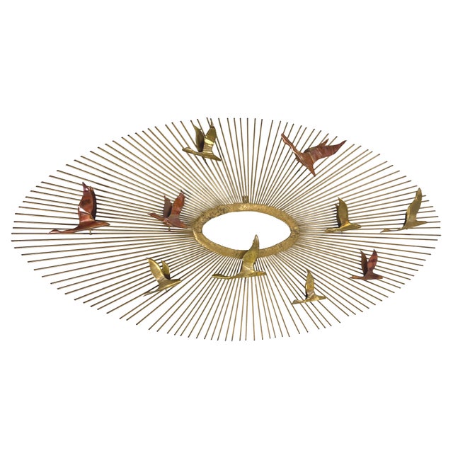 Vintage 1960s wall sculpture featuring nine stylized birds in flight arranged across a large radiating starburst,...