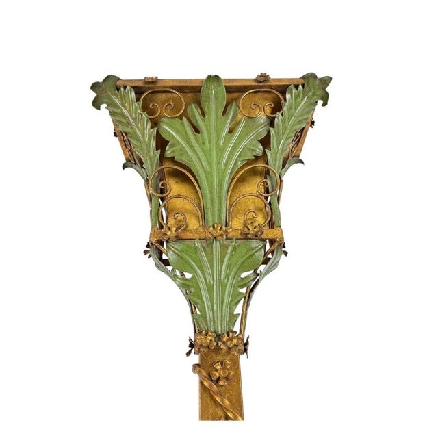 Italian wall mount sconce with verdigris and gilt foliate design and a long, torch stem with scroll details. Dimensions:...