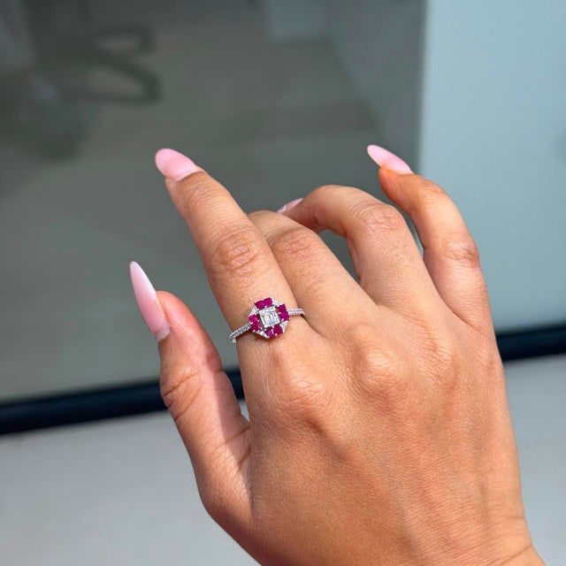 This geometric cluster ring showcases 0.65 carats of natural rubies, set in 14k white gold. The square-cut rubies...