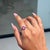 This geometric cluster ring showcases 0.65 carats of natural rubies, set in 14k white gold. The square-cut rubies...