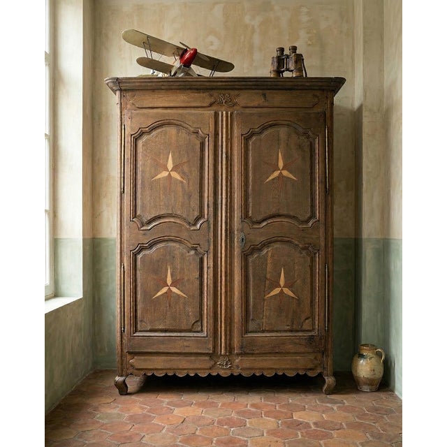 Beautiful rustic French Louis XV style armoire, decorated with four stars with inlays from different types of wood, early...