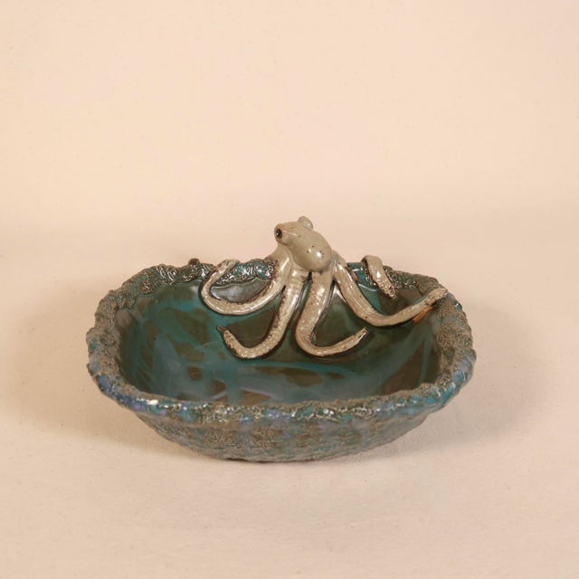 A beautifully handcrafted studio pottery bowl featuring a whimsical sculptural octopus emerging over the rim, its...